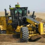 Heavy-duty Caterpillar bulldozer working on construction site with earthmoving equipment.