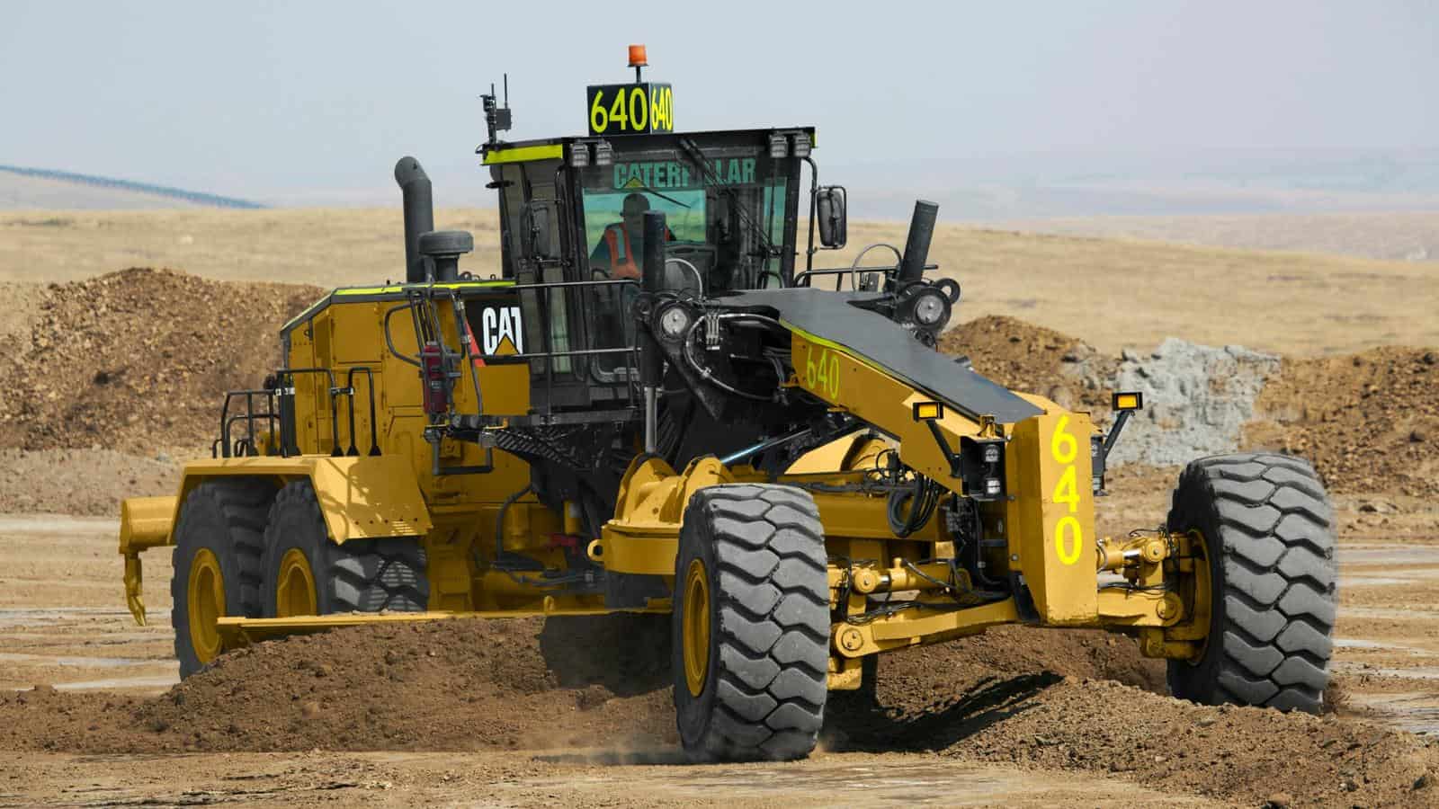 Heavy-duty Caterpillar bulldozer working on construction site with earthmoving equipment.