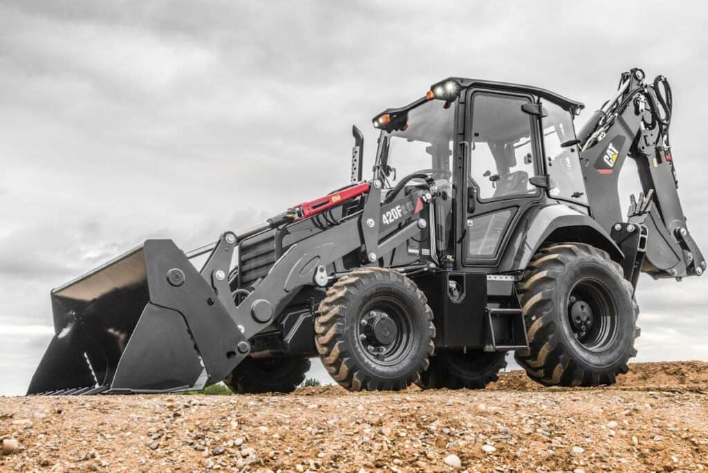 High-capacity CAT 420F backhoe loader on construction site with durable tires, equipped for heavy-duty earthmoving, excavation, and construction projects.